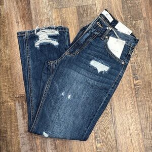 Distressed, never worn, not boot cut but wider at ankle